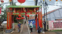 Warga memasang lampion dan menghias gapura dengan pernak-pernik imlek di Kampung Haji Bona, Depok, Jawa Barat, Kamis (19/1/2023). Bagi masyarakat Tionghoa, Imlek merupakan hari raya yang dirayakan sangat meriah oleh masyarakat keturunan China di seluruh dunia. (merdeka.com/Arie Basuki)