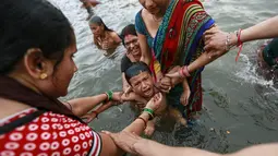 Seorang anak menangis saat dimandikan di Sungai Godavari saat Festival Pitcher, India, Jumat (28/8/2015). Ratusan ribu umat Hindu mengambil bagian dalam perayaan keagamaan yang diadakan setiap 12 tahun sekali di Sungai Godavari. (REUTERS/Danish Siddiqui)