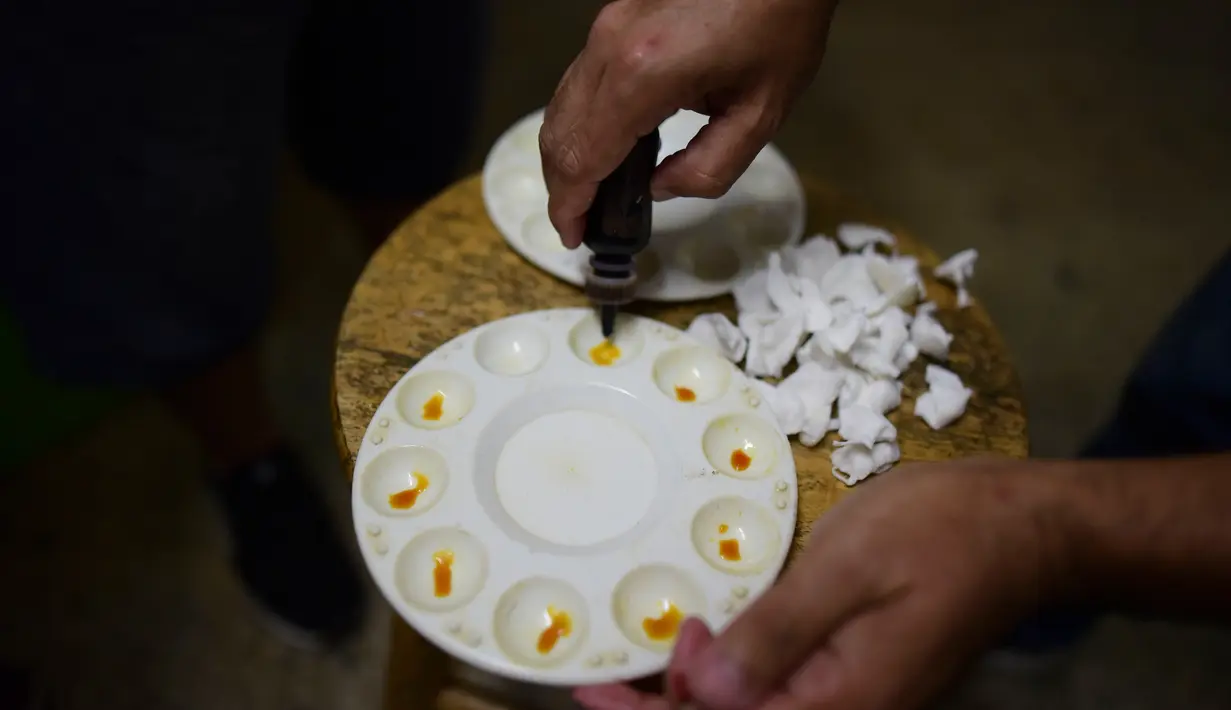 Dewan juri Xavier Guevares menyiapkan larutan alkaloid untuk mengecek kemungkinan penggunaan zat ilegal pada ayam sebelum bertarung di klub sabung ayam Campanillas, Toa Baja, Puerto Rico, Rabu (18/12/2019). Larutan digosokkan pada taji untuk mendeteksi racun atau zat ilegal. (AP Photo/Carlos Giusti)