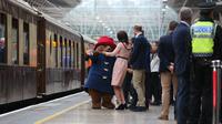 Kate Middleton asyik berdansa dengan seorang aktor yang mengenakan kostum Paddington di stasiun kereta Paddington, London, Senin (16/10). Ini merupakan kemunculan kedua Kate di publik sejak pengumuman kehamilan ketiganya. (Jonathan Brady/Pool via AP)
