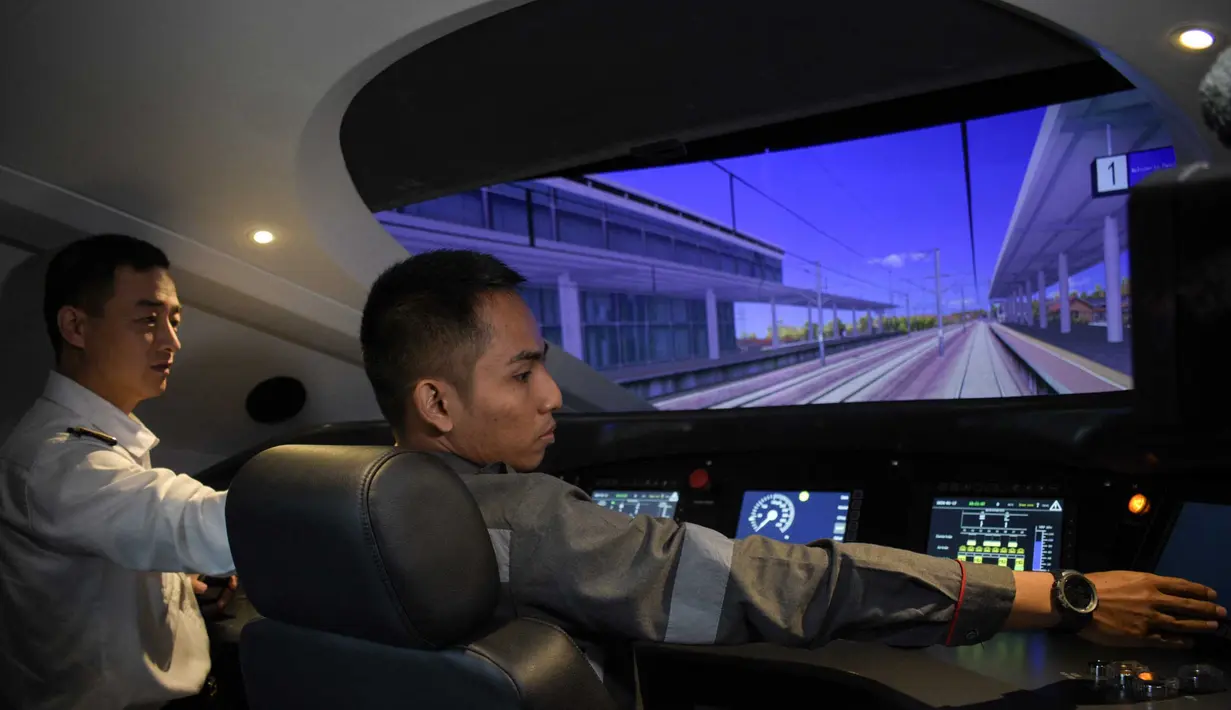Seorang peserta pelatihan masinis untuk kereta cepat Jakarta-Bandung "Whoosh" dipandu oleh seorang instruktur asal China dalam simulator mengemudi di depo stasiun Tegalluar, Bandung, Jawa Barat, pada 17 Januari 2024. (Timur MATAHARI/AFP)