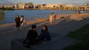 Orang-orang berjalan di sepanjang sungai Han dengan pemandangan cakrawala Seoul di taman Yeouido, Rabu (26/9). Korea Selatan sedang menikmati hari terakhir dari liburan Chuseok atau Hari Thanksgiving. (AFP PHOTO / Ed JONES)