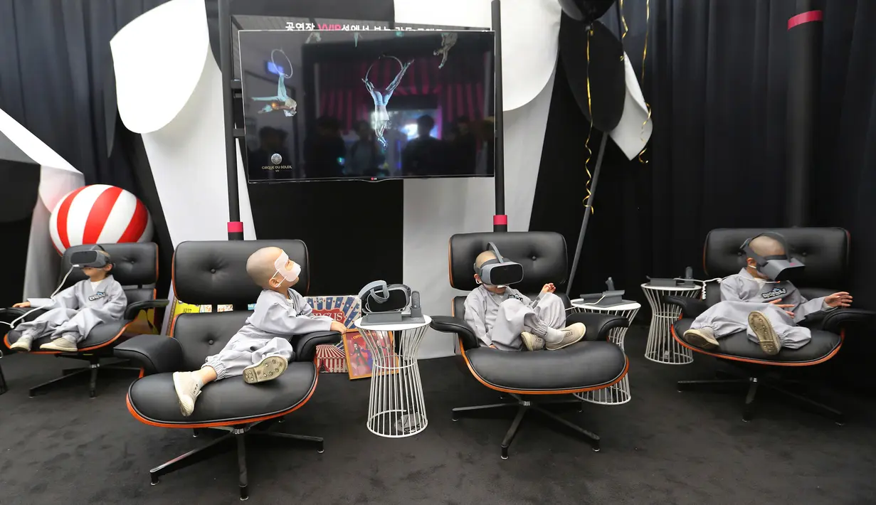 Empat anak lelaki berkepala botak bermain Virtual Reality (VR) menggunakan layanan 5G di tempat pengalaman LG UPlus 5G di Seoul, Korea Selatan (7/5/ 2019). Sepuluh anak terpilih mendapatkan pengalaman menjadi biksu dalam rangkaian acara peringatan hari lahir Buddha. (AP Photo/Ahn Young-joon)