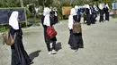 Anak perempuan meninggalkan sekolah mereka setelah perintah penutupan hanya beberapa jam setelah dibuka kembali di Kabul (23/3/2022). Penutupan sekolah memicu kebingungan dan patah hati atas peristiwa tersebut. pembalikan kebijakan oleh kelompok Taliban. (AFP/Ahmad Sahel Arman)