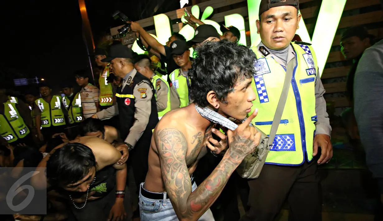 Puluhan remaja yang terlibat bentrokan dengan aparat polisi digelandang ke Polda Metro Jaya, Jakarta, Minggu (18/10).  Mereka diamankan karena melempar petasan dan batu ke arah polisi di jalan Sudirman. (Liputan6.com/Immanuel Antonius)