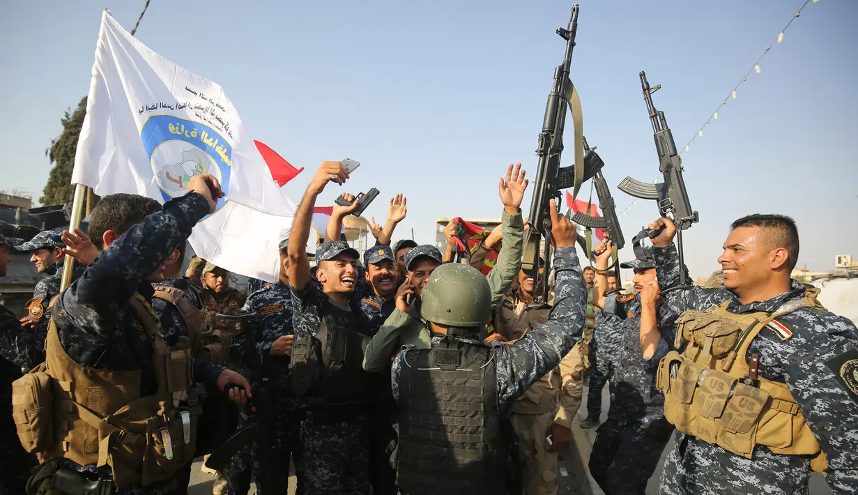 Anggota polisi Federal Irak  merayakan keberhasilan menyingkirkan militan ISIS dari Kota Tua Mosul, Minggu (9/7). Kantor PM Irak Haider al-Abadi mengumumkan kemenangan atas ISIS di kota itu setelah bertempur selama delapan bulan. (AHMAD AL-RUBAYE/AFP)