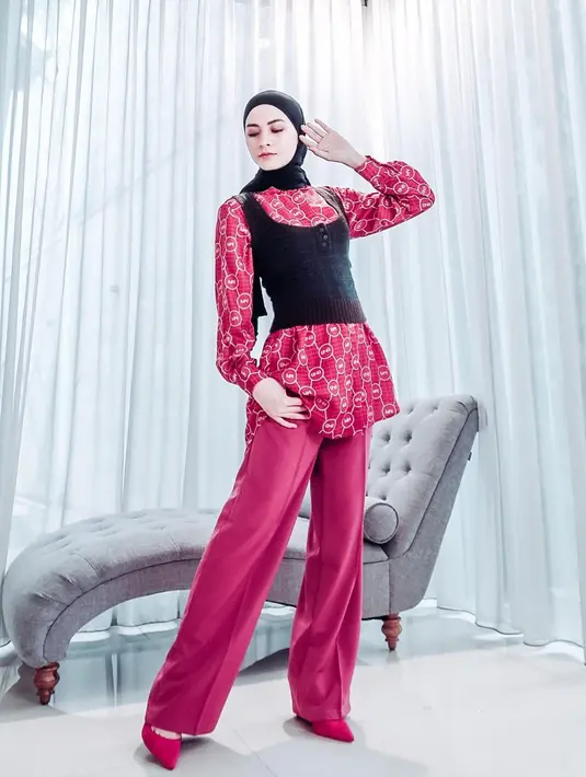 Gaya OOTD Donita dengan busana berwarna merah dan hitam ini juga bisa ditiru. Menggunakan blouse merah motif, ia memilih menambahkan detail rajutan hitam yang senada dengan hijabnya. (Liputan6.com/IG/@donitabhubiy)