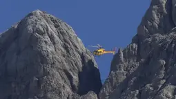 Helikopter penyelamat terbang di atas gletser Punta Rocca yang runtuh dekat Canazei di Pegunungan Alpen Italia di Italia utara (4/7/2022). Sedikitnya enam pejalan kaki tewas dan melukai delapan lainnya. (AP Photo/Luca Bruno)
