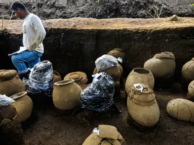 Pekerja Nicaraguan Institute of Culture (INC) mendata sejumlah tembikar di situs pemakaman zaman pra-Kolombia berusia lebih dari 1.200 tahun yang ditemukan di lokasi pembangunan Stadion Bisbol Nasional yang baru di Managua, Selasa (20/6). (INTI OCON/AFP)