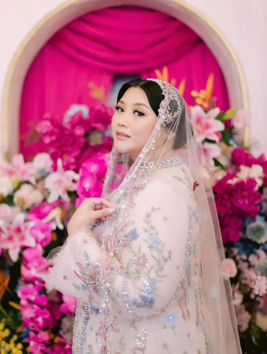 Dia menyelesaikan penampilannya dengan pulasan makeup flawless dalam rona pink segar karya @fidelhertamakeup. [@clarissaputri_].