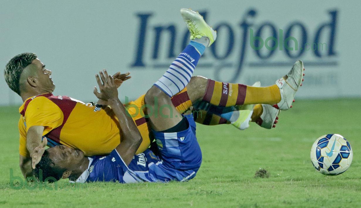 Cristian Gonzales, striker Arema Cronus terjatuh dan menindih pemain Persib Bandung di turnamen sepak bola Bali Island 2016 di Stadion Kapten I Wayan Dipta, Gianyar, Bali Selasa (23/2/2016). (Bola.com/Peksi Cahyo)