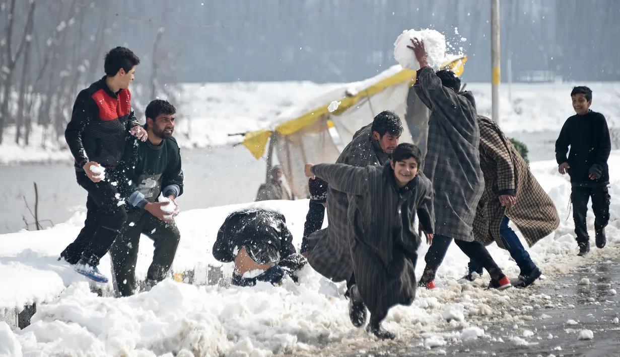 Pemuda Kashmir bermain dengan salju di tepi Danau Dal setelah salju turun di Srinagar, India bagian utara, Sabtu (5/1). Wilayah Kashmir mengalami salju selama beberapa hari yang mengakibatkan terputus jalan raya Jammu-Srinagar. (TAUSEEF MUSTAFA/AFP)