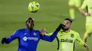 Pemain Atletico Madrid, Yannick Carrasco, duel udara dengan pemain Getafe, Allan Nyom, pada laga Liga Champions di Stadion Alfonso Perez, Sabtu (13/3/2021). Kedua tim bermain imbang 0-0. (AP/Manu Fernandez)