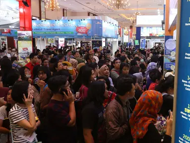 Pengunjung mencari berbagai promo jalan-jalan dalam Garuda Indonesia Travel Fair (GATF) 2018 di Jakarta Covention Centre, Jumat (5/4). Garuda Indonesia Travel Fai kembali digelar pada 6 - 8 April 2018 dengan tema More For Less. (Liputan6.com/Angga Yuniar)