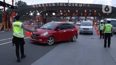 Petugas gabungan mengarahkan pengendara mobil untuk putar balik saat akan memasuki wilayah Jakarta di Gerbang Tol Cikupa, Tangerang, Rabu (27/5/2020). Kendaraan yang menuju Jakarta wajib menunjukkan Surat Izin Keluar atau Masuk (SIKM) untuk menekan penyebaran Covid-19. (Liputan6.com/Angga Yuniar)