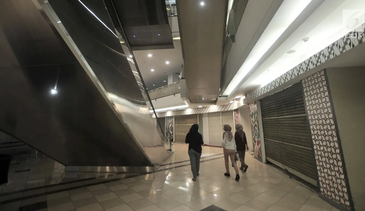 Pengunjung melintasi kios pertokoan yang tutup di pusat perbelanjaan kawasan Semanggi, Jakarta, Senin (28/1). Pasar ritel nasional mengalami penurunan dalam dua tahun terakhir akibat menjamurnya platform penjualan e-commerce. (Merdeka.com/Iqbal S Nugroho)