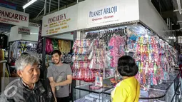 Sejumlah pembeli melintasi kios jam tangan di Blok III Pasar Senen, Jakarta, Rabu (24/6/2015). Para pedagang korban kebakaran Blok III Pasar Senen masih menempati kios sementara hingga gedung baru selesai. (Liputan6.com/Faizal Fanani)