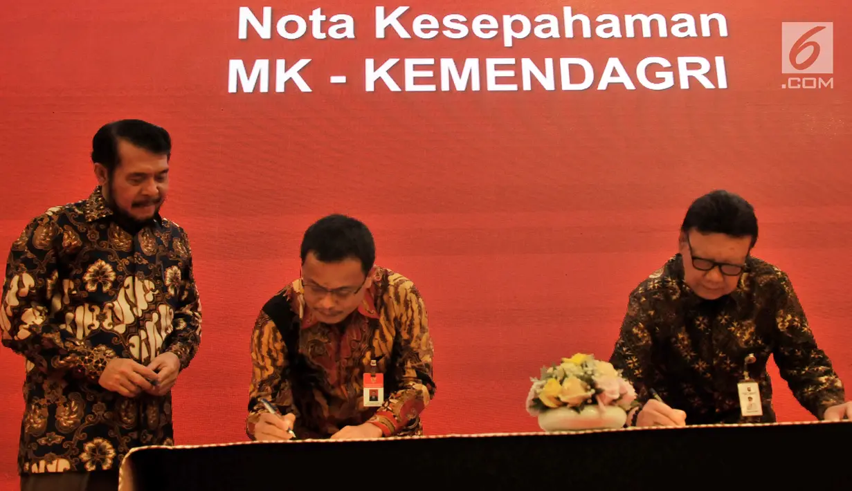 Mendagri Tjahjo Kumolo (kanan) menandatangai Nota Kesepahaman dengan OJK, MK, KLHK, dan PPATK di Jakarta, Selasa (19/2). Menurut Tjahjo, kerja sama ini untuk meningkatkan kualitas pelayanan publik serta perencanaan pembangunan. (Merdeka.com/Iqbal Nugroho)
