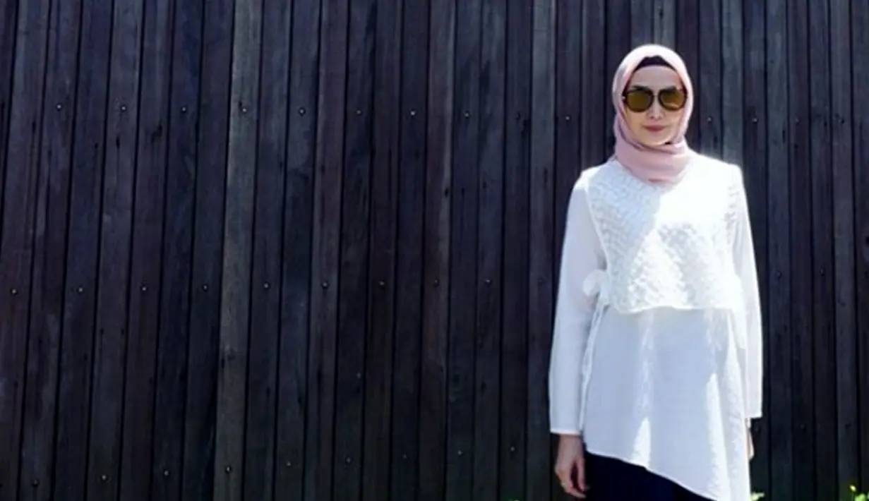 Istri Arie Untung, Fenita Arie berpose dengan mengenakan hijab dengan dengan baju putih dan aksesori kacamata. Fenita memutuskan berhijab sejak awal tahun 2018. (Instagram/fenitarie)