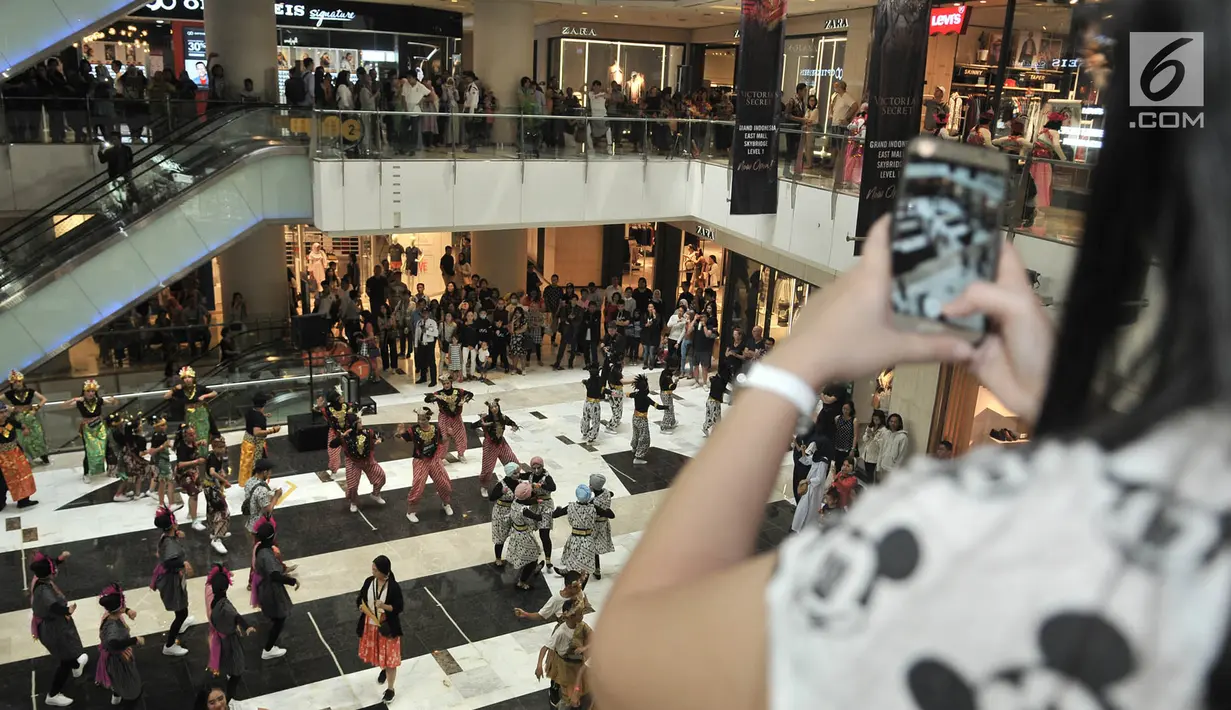 Pengunjung mengambil gambar perhelatan Indonesia Menari 2018 di Grand Indonesia, Jakarta, Minggu (11/11). Sebanyak 1500 penari menari serentak di Grand Indonesia dengan konsep penggabungan tarian tradisional dan modern. (Merdeka.com/ Iqbal S. Nugroho)