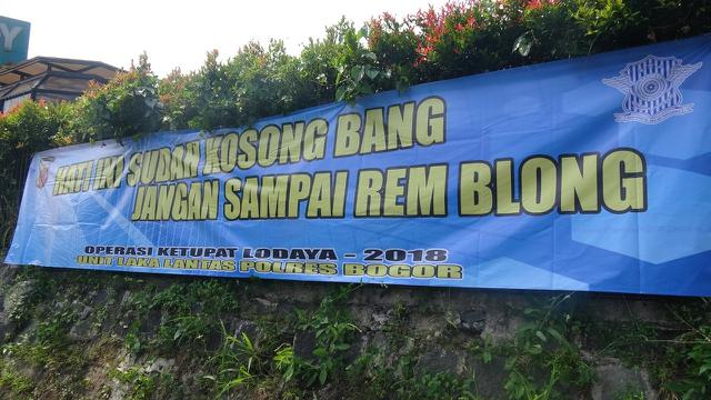 Spanduk imbauan tertib lalu lintas di kawasan Puncak, Bogor membuat pengguna jalan merasa terhibur (Liputan6.com/Achmad Sudarno)