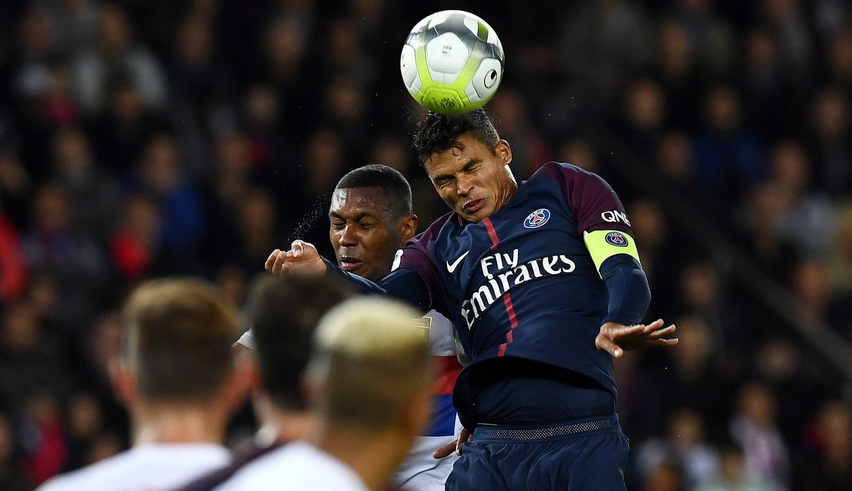 Pemain PSG, Thiago Silva (kanan) berusaha menyundul bola ke gawang Lyon pada lanjutan Ligue 1 Prancis di Parc des Princes stadium, Paris, (17/9/2017). PSG menang 2-0. (AFP/Franck Fife)