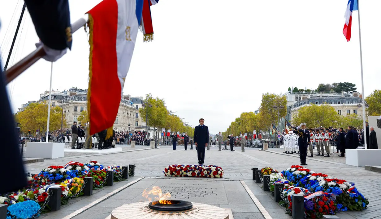 Presiden Prancis Emmanuel Macron berdiri di Makam Prajurit Tak Dikenal saat upacara di Arc de Triomphe, Paris, Prancis, 11 November 2022. Upacara ini digelar untuk menandai peringatan 104 tahun Gencatan Senjata 11 November 1918 yang mengakhiri Perang Dunia I. (Gonzalo Fuentes/Pool via AP)