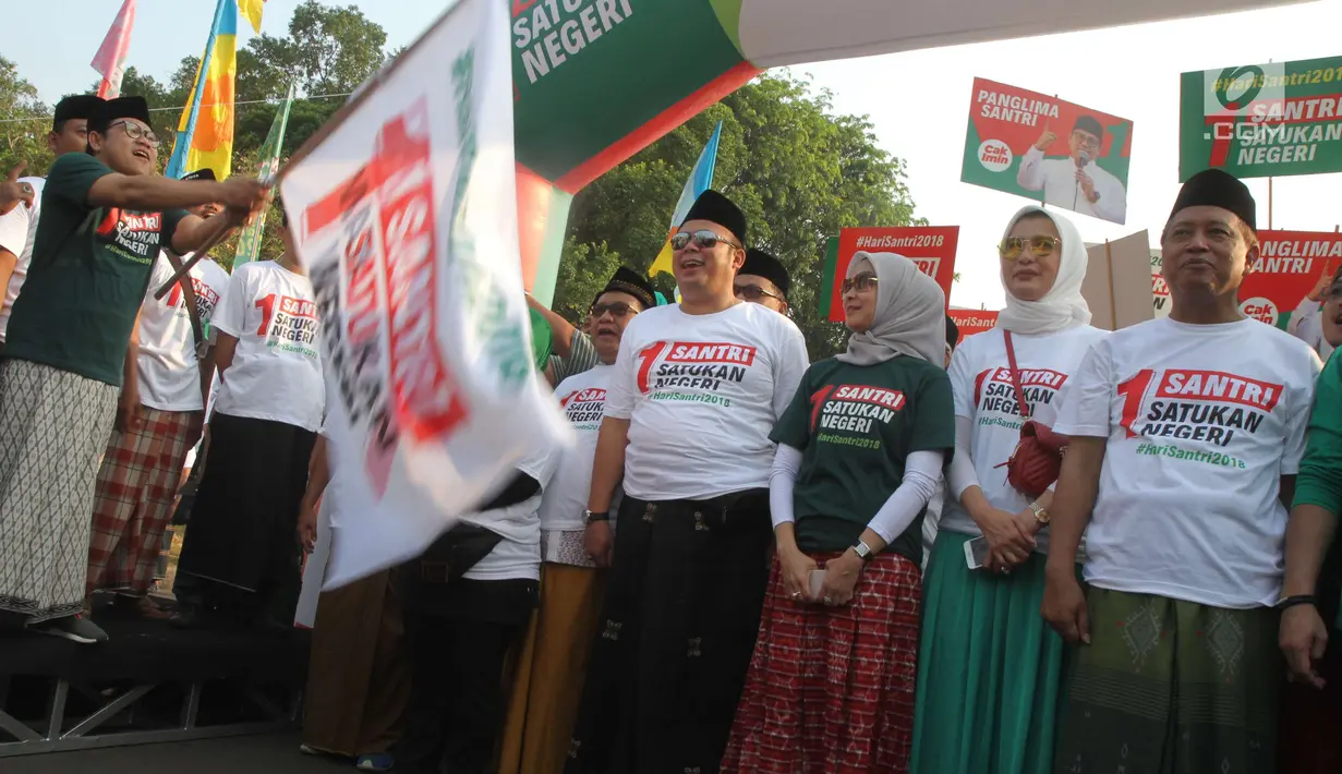 Ketua Umum Partai Kebangkitan Bangsa (PKB) Muhaimin Iskandar melepas peserta jalan sehat sarungan di kawasan Monas, Jakarta, Minggu (30/9). Kegiatan ini diikuti ratusan santri yang semuanya menggunakan sarung. (Liputan6.com/Angga Yuniar)