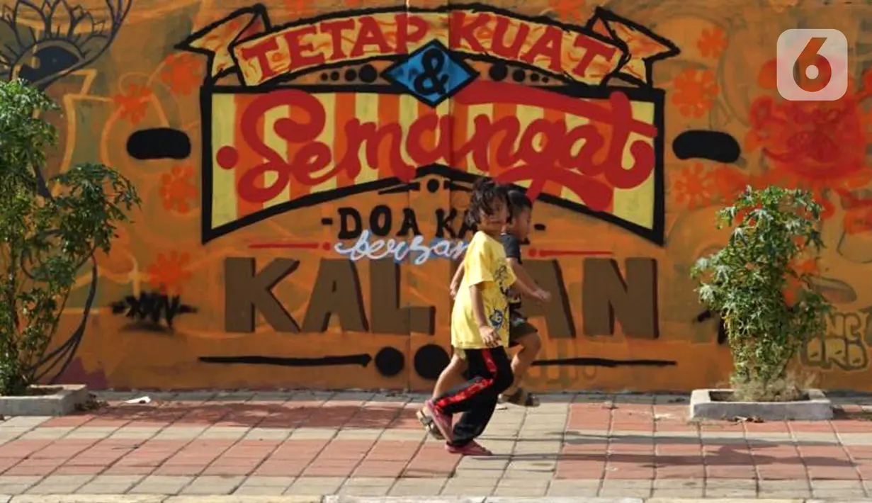Anak-anak berjalan di depan mural bertema pandemi virus corona COVID-19 di kawasan Sunter, Jakarta, Selasa (2/6/2020). Mural tersebut dibuat sebagai wujud dukungan terhadap tenaga medis serta masyarakat agar tetap semangat menghadapi pandemi COVID-19. (Liputan6.com/Immanuel Antonius)