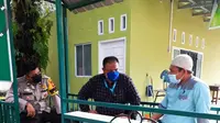 Personel Polsek Tampan berbincang dengan pengurus yayasan pesantren yang gurunya keracunan makanan. (Liputan6.com/M Syukur)