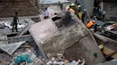 Petugas penyelamat mengevakuasi korban yang terjebak puing bangunan lima lantai yang runtuh di daerah permukiman di ibu kota Kenya, Nairobi, Minggu (4/6). Belum jelas yang menjadi sebab runtuhnya gedung tersebut. (AP Photo/Ben Curtis)