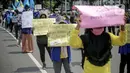 Massa Gabungan Serikat Buruh Indonesia (GSBI) membawa pembalut wanita saat berunjuk rasa di kawasan Patung Kuda, Jakarta, Senin (16/11/2020). GSBI meminta pemerintah mencabut UU Cipta Kerja serta menaikkan upah buruh 2021 sesuai kebutuhan rill buruh dan keluarga. (Liputan6.com/Faizal Fanani)