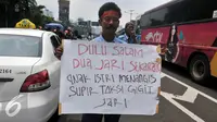 Seorang sopir taksi membawa spanduk saat demo di depan Gedung DPR/MPR, Jakarta, Selasa (22/3). Selain melakukan demo, sopir taksi tersebut melakukan sweeping ke supir taksi yang beroperasi di dalam tol dan membakar ban. (Liputan6.com/Johan Tallo)