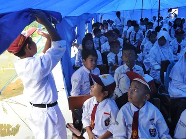 Murid-murid berada di dalam tenda darurat  akibat bangunan atau kelas roboh saat hujan deras  pada hari Rabu (1/1/2020) lalu di SDN Cirimekar 2, Cibinong, Bogor, Senin (6/1/2020). (merdeka.com/Arie Basuki)