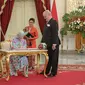 Ratu Denmark Margrethe II mengisi buku tamu disaksikan Presiden Jokowi (kiri) saat melakukan kunjungan kenegaraan di Istana Merdeka, Jakarta, Kamis (22/10). Pertemuan keduanya untuk mempererat hubungan kerja sama. (Liputan6.com/Faizal Fanani)