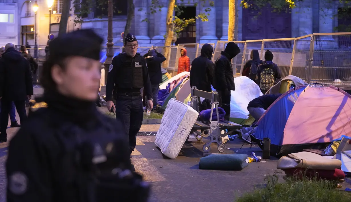 Dalam operasi sebelum fajar, polisi membangunkan sekitar 100 remaja laki-laki dan pmuda dari Afrika Barat serta mendesak mereka untuk mengemasi tenda dan barang-barang mereka. (AP Photo/Michel Euler)