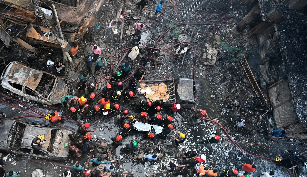 Petugas penyelamat membawa jenazah korban setelah kebakaran di gedung apartemen di Dhaka (21/2). Setidaknya 69 orang tewas dalam kebakaran besar yang melanda gedung  yang juga digunakan sebagai gudang bahan kimia. (AFP Photo/Munir Uz Zaman)