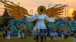 Orang-orang berkumpul di depan "Sunflower Angel", instalasi seni fiberglass setinggi sembilan meter karya seniman lokal Arrofi Ramadhan, di Candi Prambanan, kompleks candi Hindu abad ke-9 yang terdaftar sebagai Situs Warisan Dunia UNESCO, Sleman, Yogyakarta, pada Sabtu 6 Juni 2026. (DEVI RAHMAN/AFP)