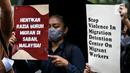 Sejumlah buruh migran membawa poster saat menggelar aksi di depan Kedutaan Besar Malaysia di Jakarta, Selasa (9/8/2022). Mereka menuntut pemerintah Malaysia melakukan perbaikan dan menghentikan berbagai praktik kejam di dalam pusat tahanan imigrasi. (Liputan6.com/Faizal Fanani)
