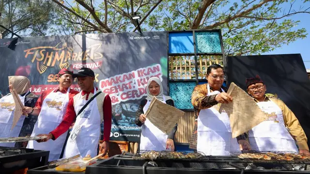 Bupati Ipuk Fiestiandani ikut membakar ikan di ajang Banyuwangi Fish Market Festival yang dipusatkan di kawasan Kampung Mandar. (Hermawan/Liputan6.com)