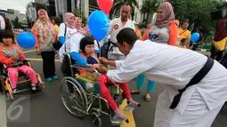 Seorang anak disabilitas mendapat balon saat mengikuti Jalan Sehat Keluarga Disabilitas (JSKD) di Pasar Akhir Pekan SCBD, Jakarta (11/12). (Liputan6.com/Fery Pradolo)