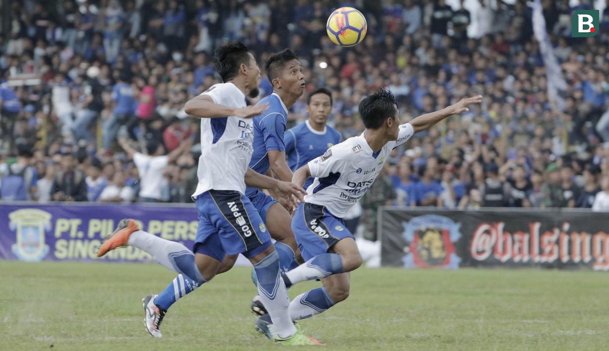 Bek Persib Bandung Henhen dan Wildansyah berusaha menghadang pemain Perserang, Ervin Rianto, pada laga persahabatan di Stadion Maulana Yusuf, Banten, Kamis (1/3/2018). Persib menang 6-0 atas Perserang. (Bola.com/M Iqbal Ichsan)