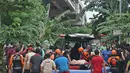 Relawan dan keluarga memasukkan jenazah warga lansia ke ambulans di tengah banjir di kawasan Cipinang Melayu, Jakarta Timur, Jumat (19/2/2021). Seorang nenek (80) meninggal di kediamannya, di lokasi banjir, di RW 04, kawasan tersebut karena sakit dan sudah lanjut usia. (Liputan6.com/Herman Zakharia)