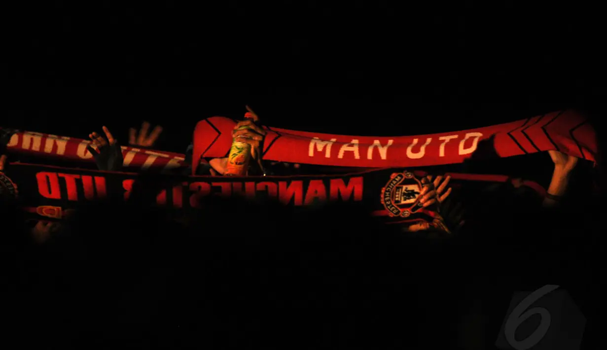 Beberapa suporter Manchester United membentangkan syal saat acara nonton bareng laga Manchester United vs Liverpool di Tanah Kusir, Jakarta, (14/12/2014). (Liputan6.com/Helmi Fithriansyah)