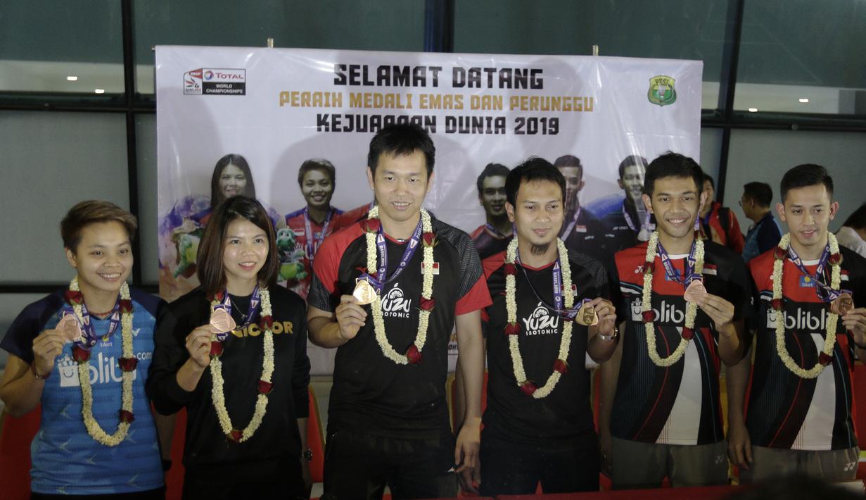 Atlet bulutangkis Indonesia menunjukan mendali saat konfrensi pers di Bandara Soekarno-Hatta, Tangerang, Selasa (27/8). Ahsan/Hendra meraih gelar pada Kejuaraan Dunia Bulutangkis 2019. (Bola.com/Yoppy Renato)