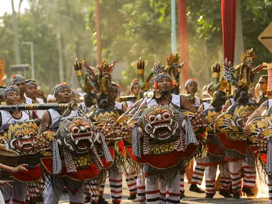 Peserta mengenakan pakaian Tari Barong pada karnaval Budaya Bali di kawasan Nusa Dua, Bali, Jumat (12/10). Karnaval tersebut untuk memeriahkan perhelatan Pertemuan Tahunan IMF - World Bank Group 2018 di Bali. (Liputan6.com/Angga Yuniar)