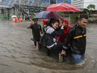 Sejumlah orang memanfaatkan jasa gerobak untuk menyeberangi banjir yang merendam Jalan Gunung Sahari, Jakarta Pusat, Selasa (21/2). Hujan deras yang mengguyur sejak Selasa dini hari membuat sebagian wilayah di Jakarta banjir. (Liputan6.com/Faizal Fanani)