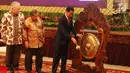 Presiden Joko Widodo didampingi Menteri Perekoniman, Darmin Nastion dan Mendag Enggartiasto Lukita memukul gong membuka secara resmi rapat kerja Kementerian Perdagangan (Kemendag) 2018 di Istana Negara, Jakarta, Rabu (31/1). (Liputan6.com/Angga Yuniar)