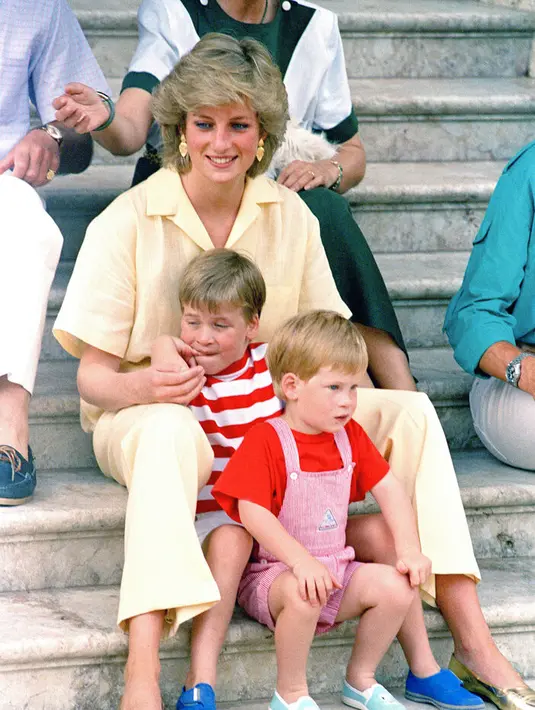 Putri Diana, yang mendapat gelar Princess of Wales bersama kedua putranya, duduk di tangga Istana Kerajaan di pulau Mallorca, Spanyol. (AP: Photo/John Redman, File )