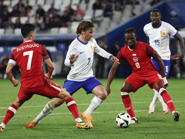 Gelandang Prancis #07 Antoine Griezmann (tengah) berebut bola dengan pemain Kanada #08 Ismael Kone (2 kanan) dan #07 Stephen Eustaquio dalam duel uji coba internasional terakhir jelang Euro 2024 di Matmut Atlantique, Bordeaux, Senin (10/6/2024) dini hari WIB. (ROMAIN PERROCHEAU / AFP)